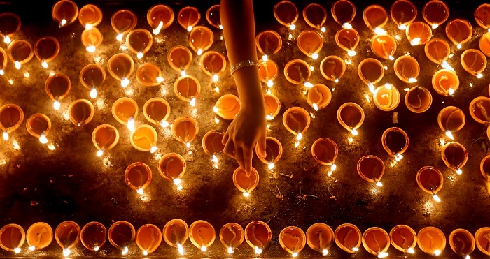 A devotee lights oil lamps at a religious ceremony during the Diwali or Deepavali festival at a Hindu temple in Colombo, Sri Lanka October 18, 2017. REUTERS/Dinuka Liyanawatte TPX IMAGES OF THE DAY