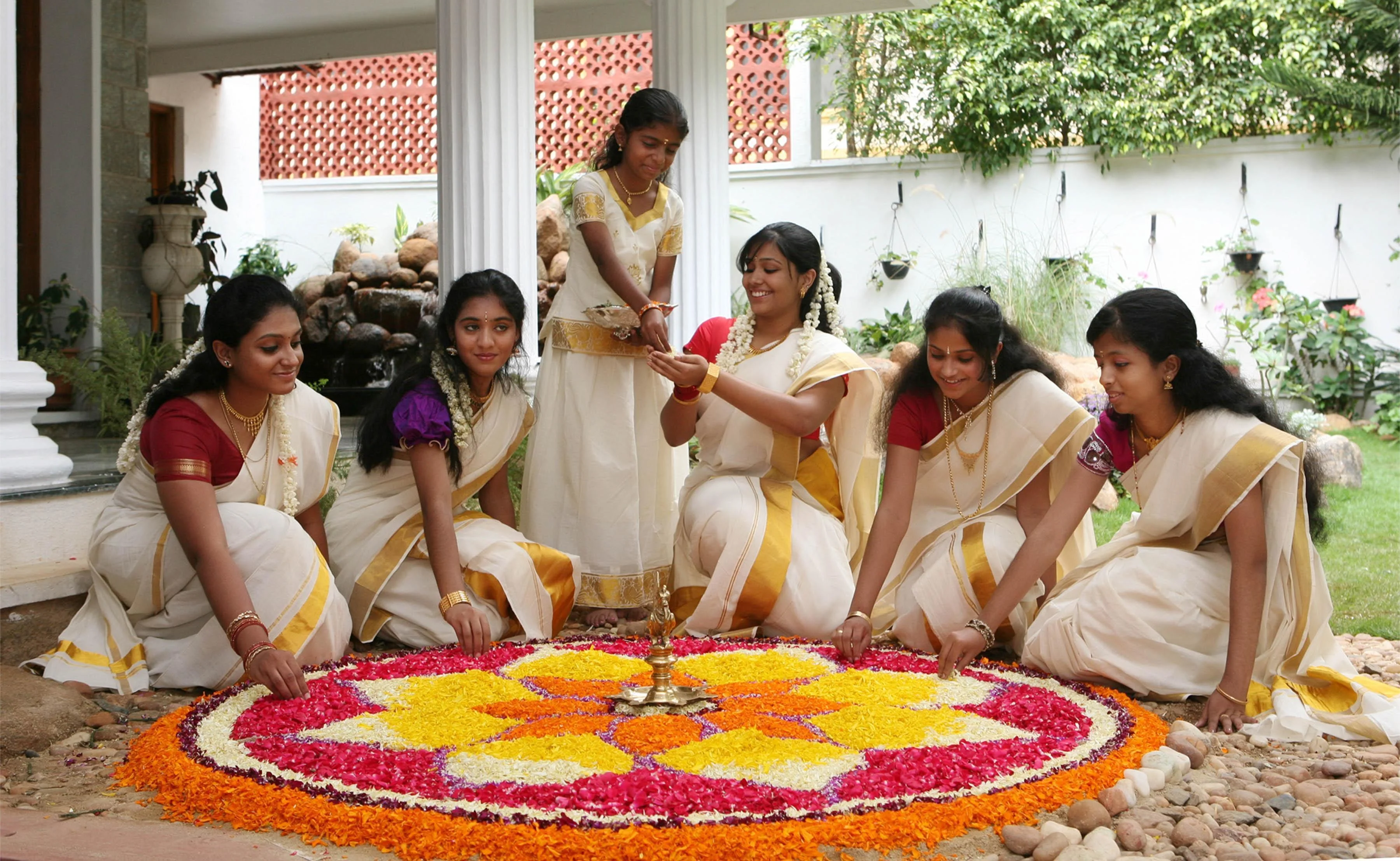 Women decorating Rangoli with flowers, on the eve of Onam Festival, in Bangalore on Sept. 6,  2014. (Photo: IANS)