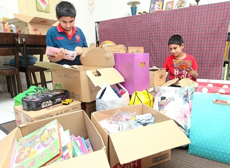 Brothers, P. Sacheen, 10 (left) and P. Rovan, eight, (right) sorting out books, stationaries and toys collected to be given to other children at their house at Bandar Putra, Kulai on Thursday (June 4).