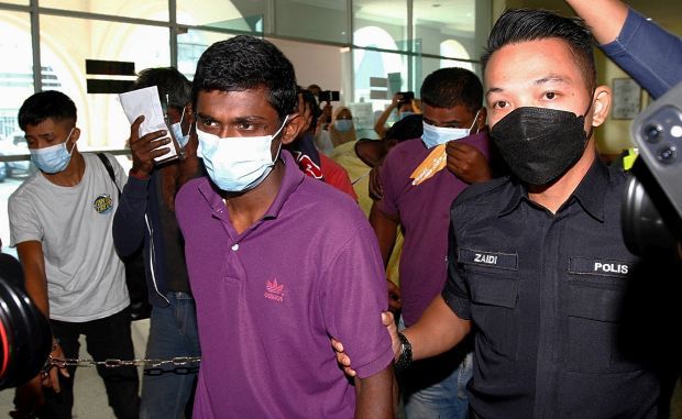 M.Kirubakaran, 29, (in purple) being escorted into court where he was charged with the murder od a 40-year-old woman and two drug related offences at the Seberang Prai (Municipal) Magistrate Court, Butterworth. ( September 7,2021 ). —ZHAFARAN NASIB/The Star