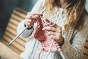 woman knitting pink yarn getty 0220 2000