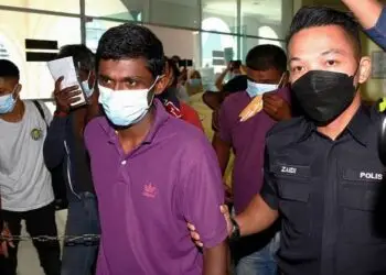 M.Kirubakaran, 29, (in purple) being escorted into court where he was charged with the murder od a 40-year-old woman and two drug related offences at the Seberang Prai (Municipal) Magistrate Court, Butterworth. ( September 7,2021 ). —ZHAFARAN NASIB/The Star